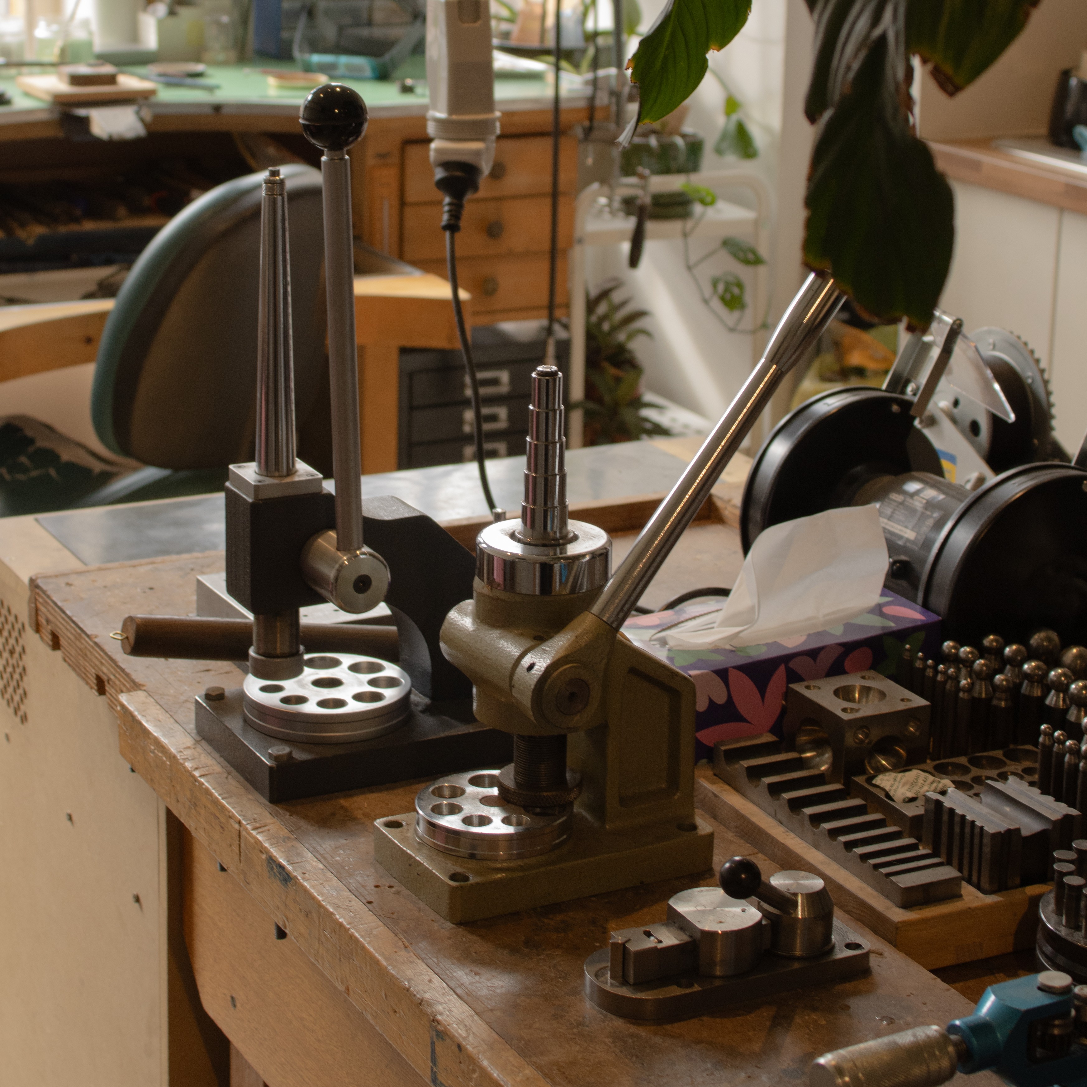 A vintage wooden desk with a mirror in the corner of a room with patterned wallpaper.
