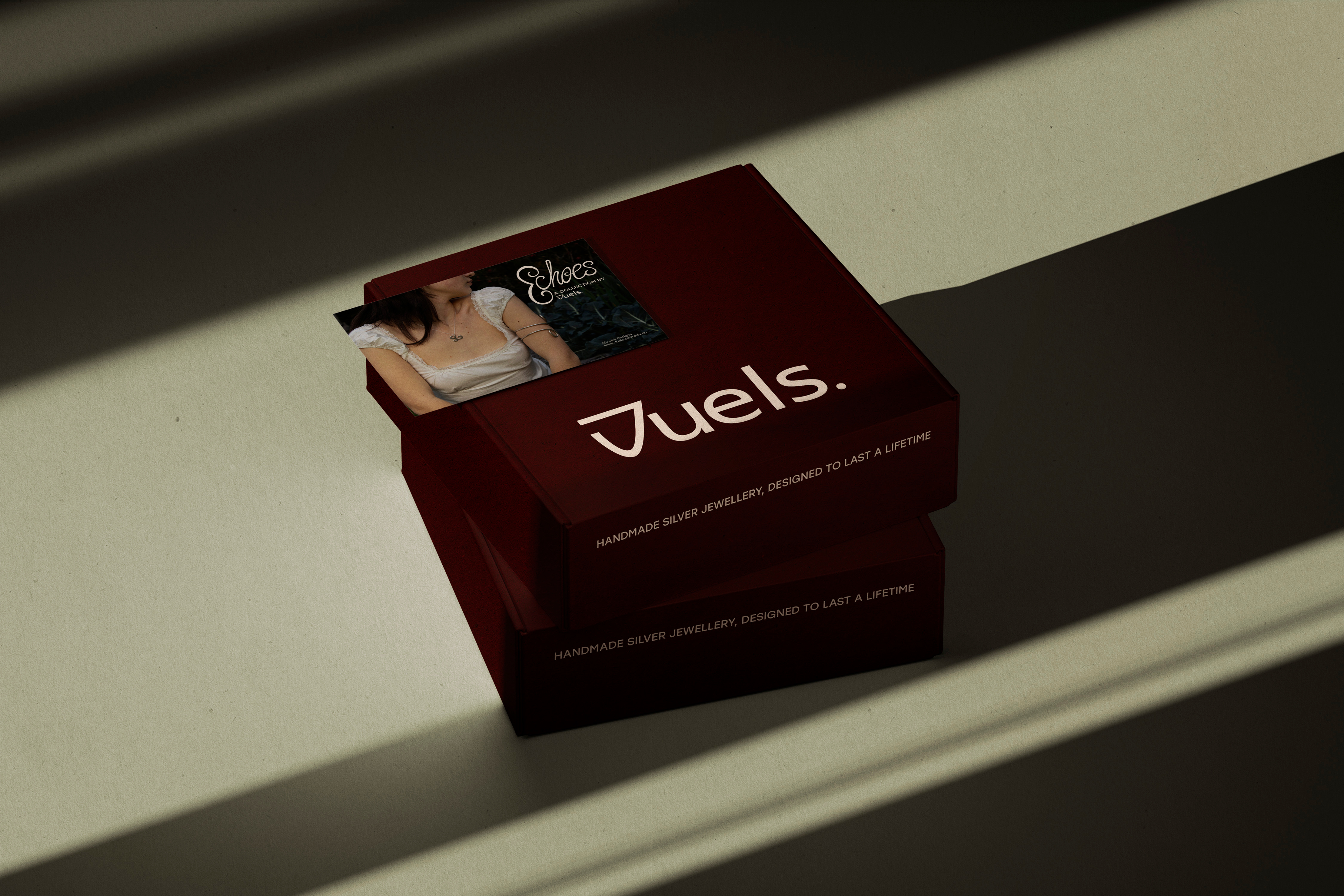 A vintage wooden desk with a mirror in the corner of a room with patterned wallpaper.